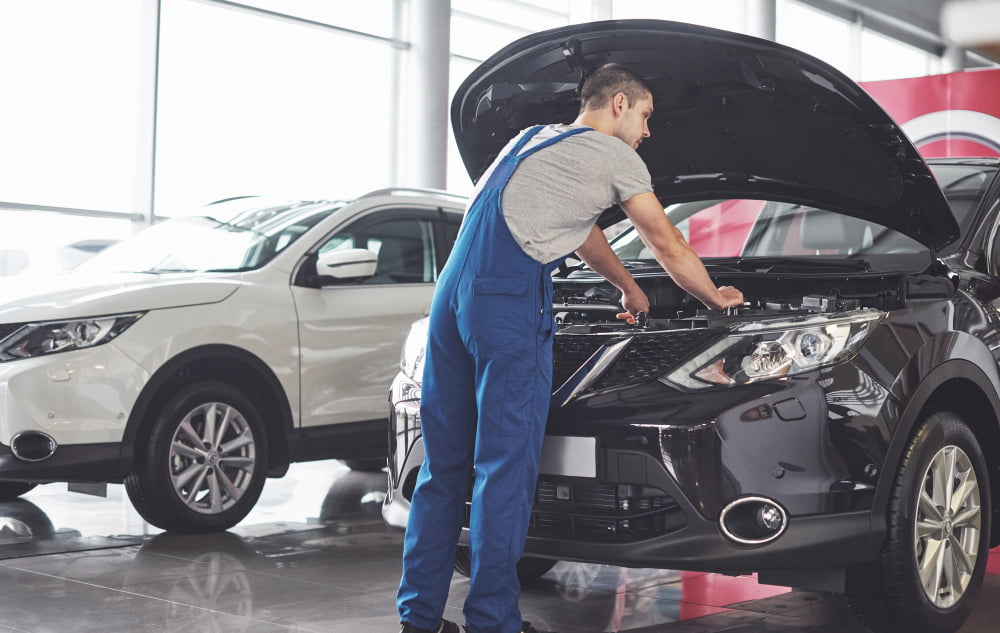 Tudo o que é preciso saber sobre manutenção de veículos! 3 muscular car service worker repairing vehicle