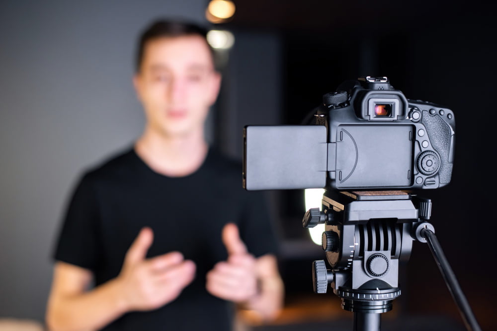 Como usar estratégia de vídeo para e-commerce? 4 man talking camera recording himself vlog working from home young content creator
